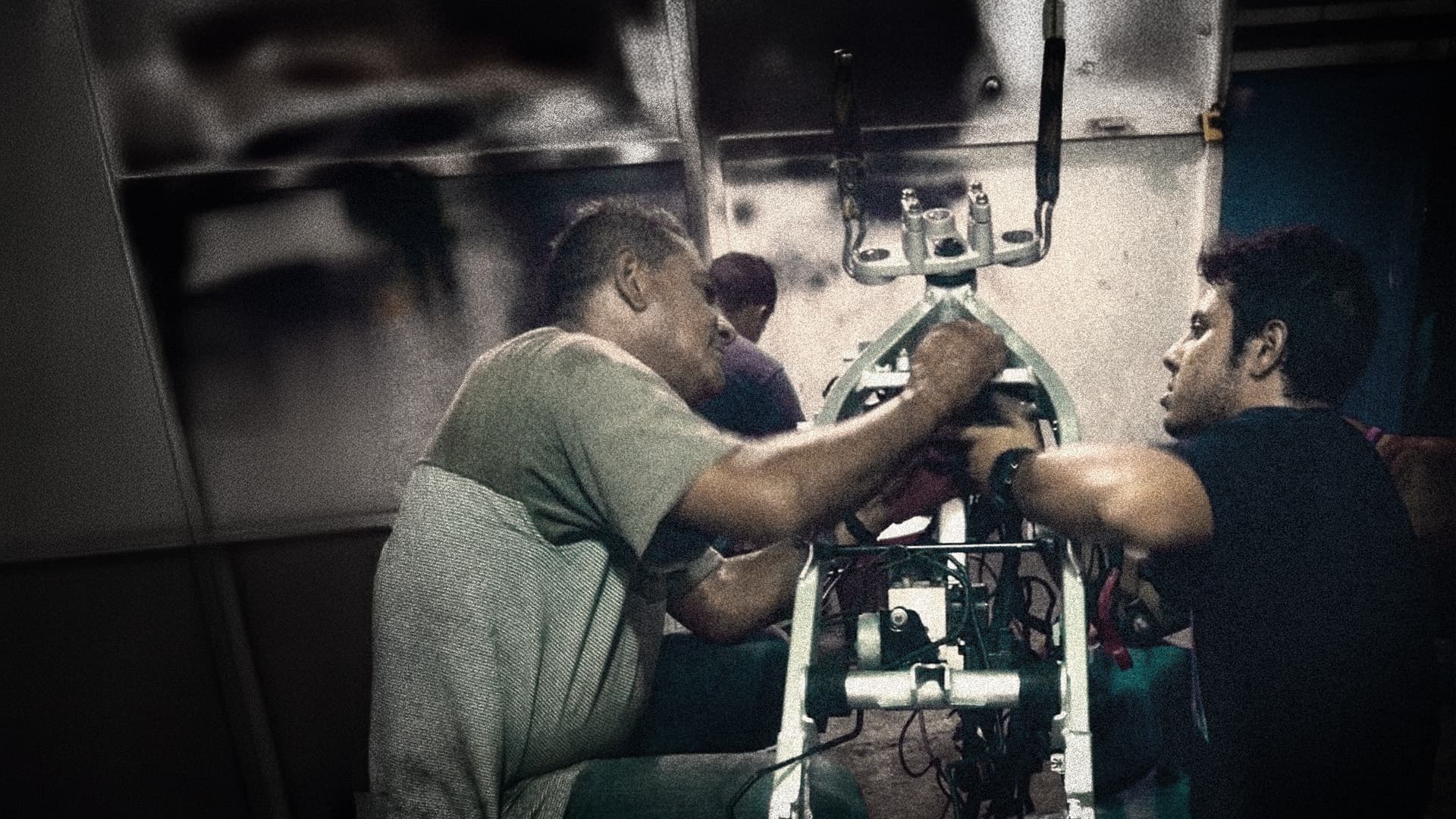 Enzo Polini and his father working on a motorcycle frame in the workshop.